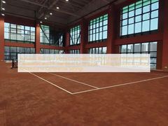 Terrain de tennis en terre battue rouge authentique avec finition en brique pilée, capacités de glissement améliorées et normes ITF pour des séances d'entraînement stratégiques dans des environnements résidentiels ou commerciaux de luxe.